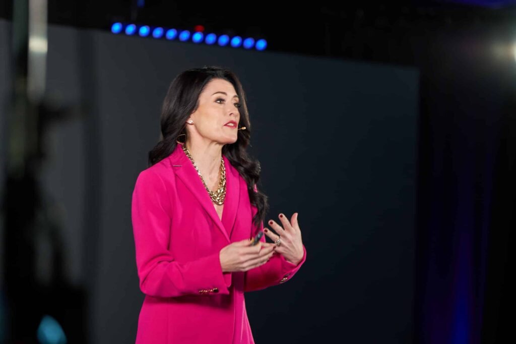 Keynote speaker in a pink blazer on stage at the Success Catalyst Summit in Tampa