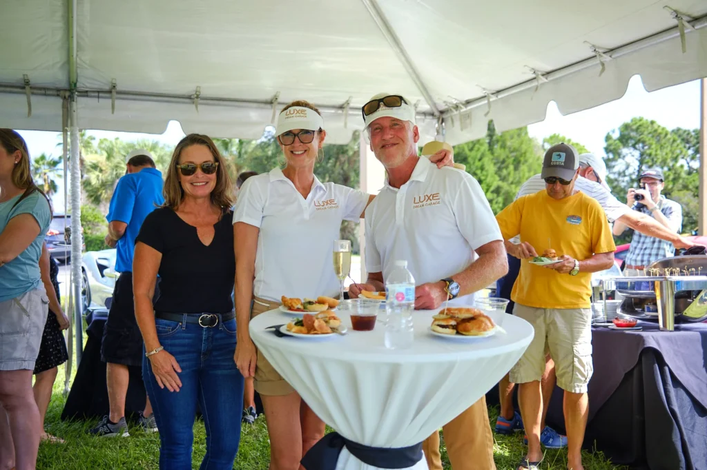 Group of event attendees pose for a photo at outdoor gathering in Sarasota