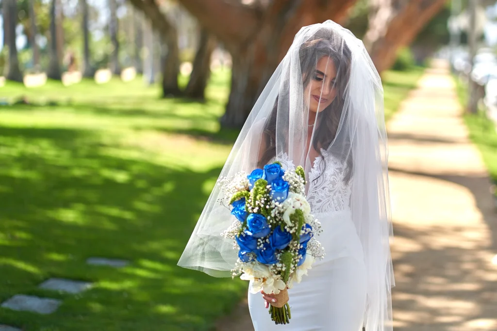 Beautiful bride photographed carrying her flower bouquet on her wedding day in the sunshine