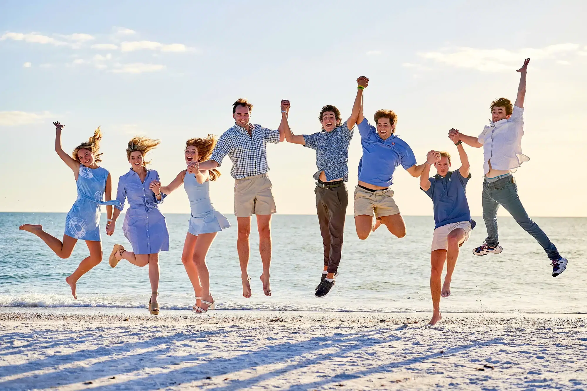 Family portrait photography jumping together Siesta Key beach at sunset