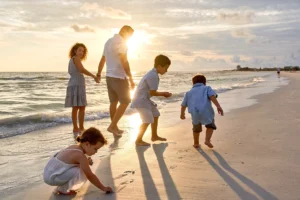 Family portrait photography walking on Siesta Key beach with sunlit background