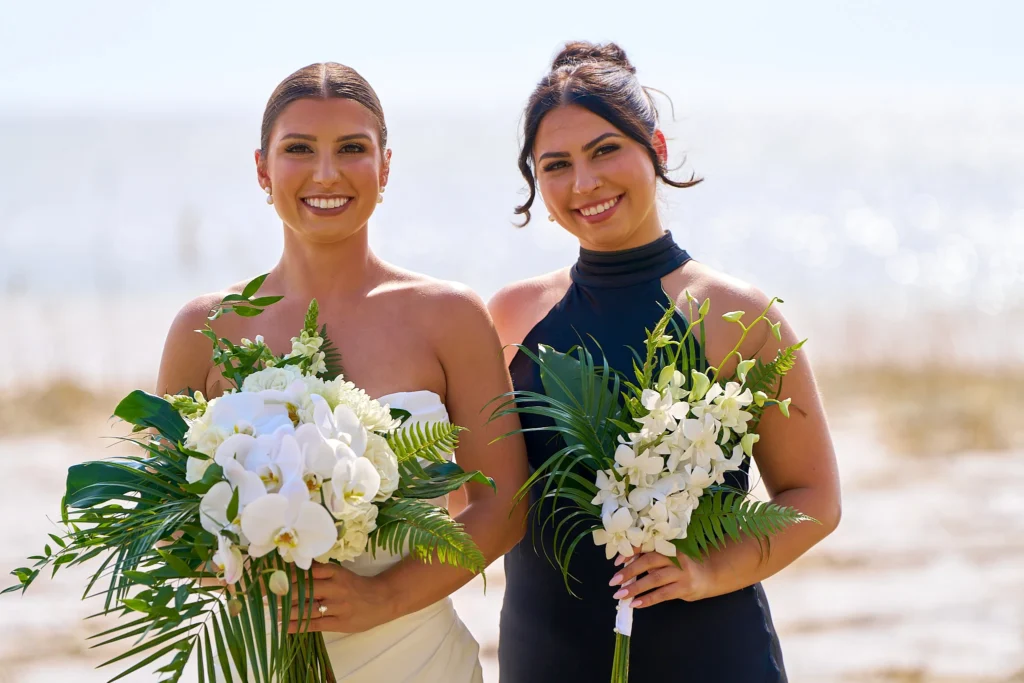 Gorgeous portrait of bride and maid-of-honor posing in front of Sarasota beach setting