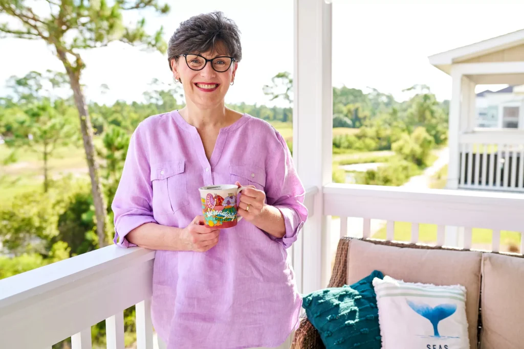 Portrait of professional woman smiling with coffee cup in morning sunlight