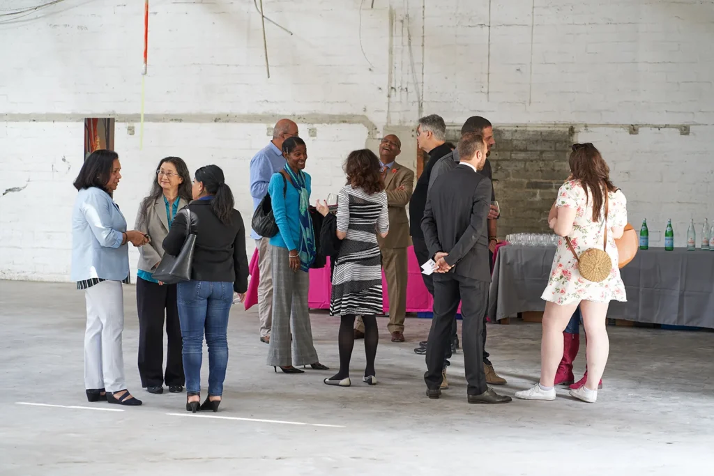 Photograph of people gathered at event networking and mingling