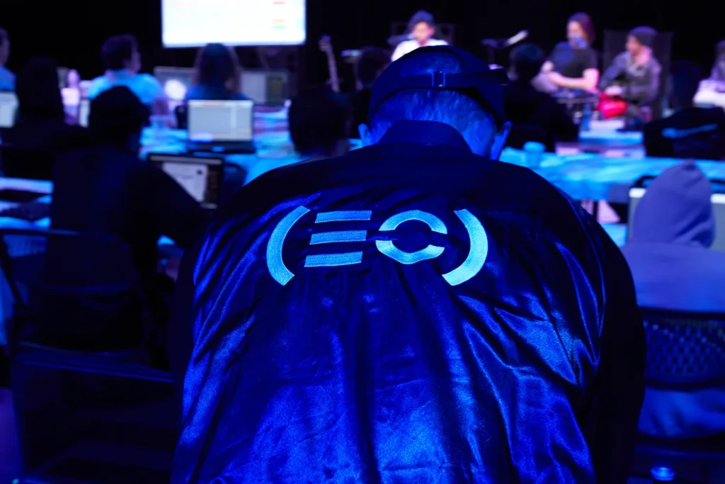 Conference photograph of man from back of room overlooking view of event