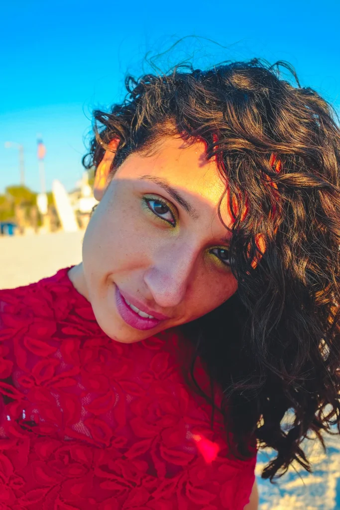 Woman model looking into the camera at beach for photography headshot portrait session at sunset